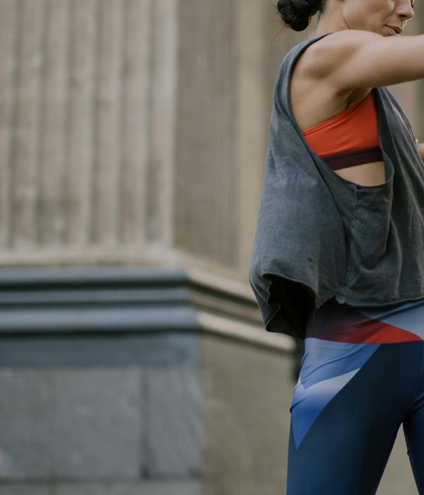 Woman in activewear performing a dynamic cardio move in a modern studio.